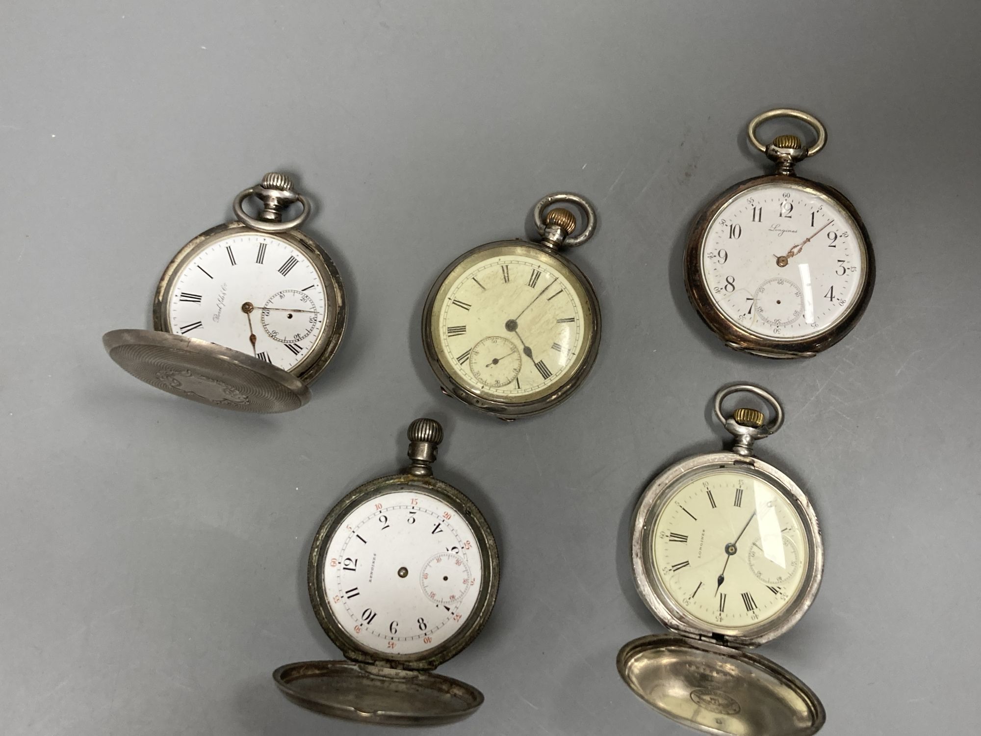 Five assorted early 20th century white metal pocket watches including three Longines (a.f.).
